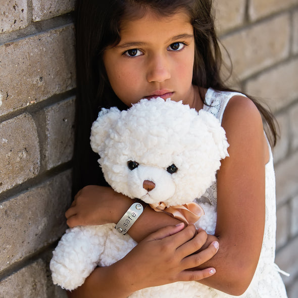 girl holding bear wearing safe band