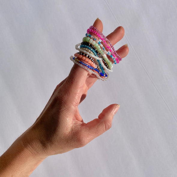 hand with beaded survivor band bracelets